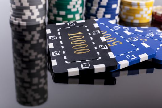 Several Casino chips on a table with reflection