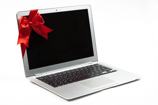 open silver laptop gift with red ribbon and black screen isolated on white background