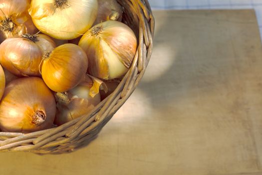 onions in basket close-up on wood backround