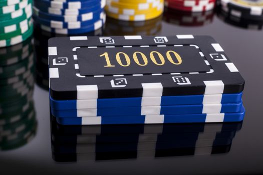 Several Casino chips on a table with reflection