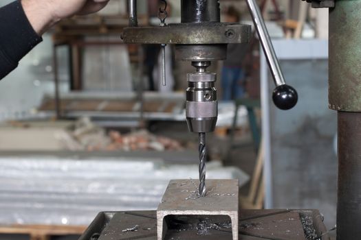 metal driling with a large drill in a workshop