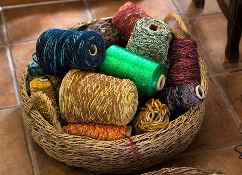 a basket full of colored threads