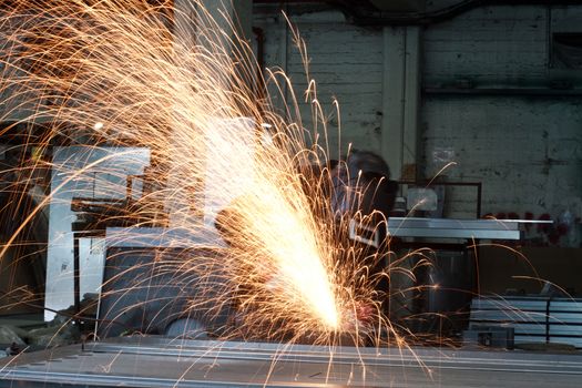 Metal worker grinding in a steel factory 