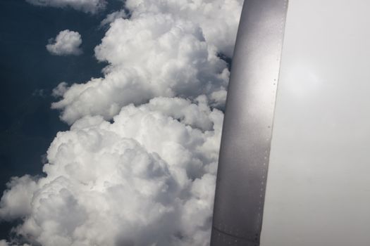 airplane engine closeup with white clouds in the background