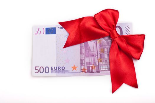 Five hundred euro banknote with a red ribbon as a gift isolated on white background