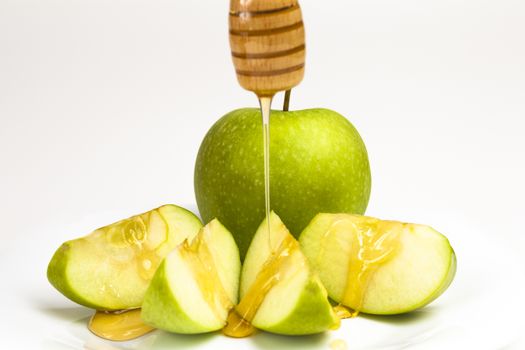 Green apple and honey isolated on white background