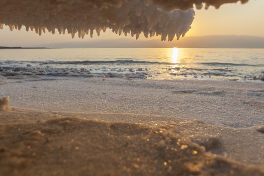 Salt Crystals formations all around on dead sea sunrise background