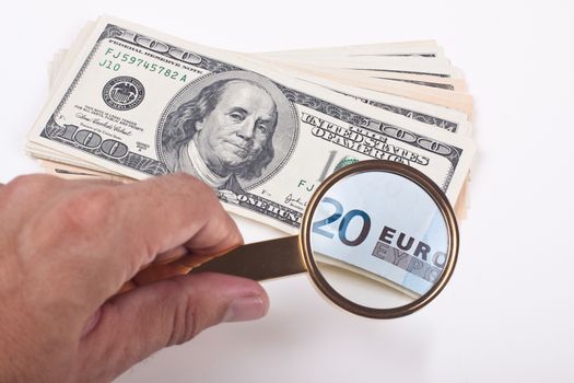 magnifying a hundred dollar bill with golden color loupe showing 20 euro bill on white background