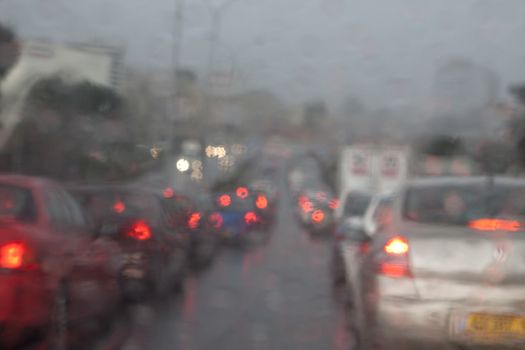 traffic jam in the rain blurred by the watter on the windshield