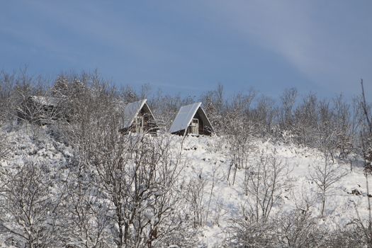 two wood cabin on a mountain in the white snow