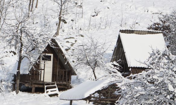 a log cabin in the snow on a mountain side