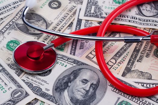 bunch of dollar bills with a red stethoscope