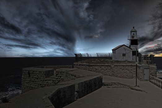 Lighhouse at the end of ancient wall at dusk