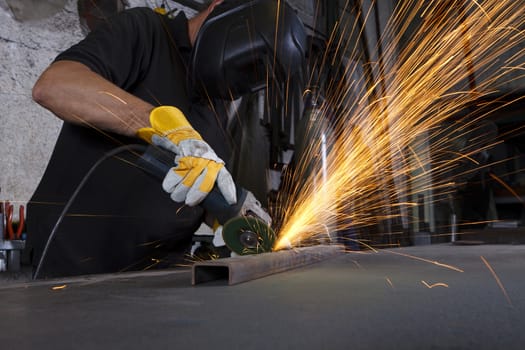 sparks flying over the working table during metal grinding