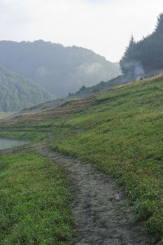 mpuntain landscape on a lake shore early morning fog and sunshine