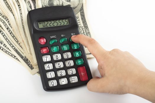 a child calculating expenses on a calculator that stands on  a couple of dollars