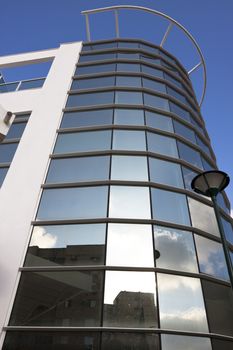 round glass office bulding exterior with blue sky in the background