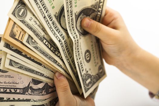 child holding and counting dollar bills on white background