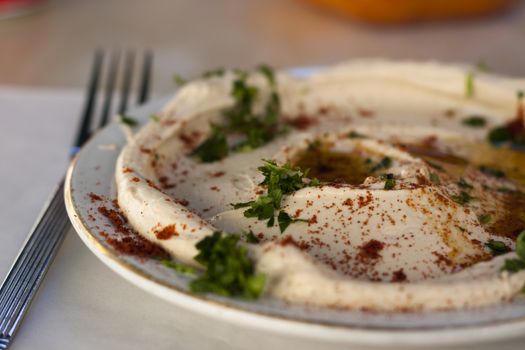 traditional humus dish with olive oil paprika and parsley