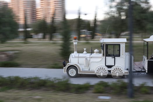 a white childrens train in the park moving background