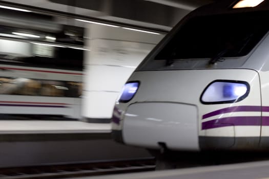 moving white train at night arriving the station