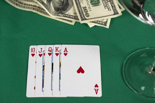 poker cards on green table with dollars