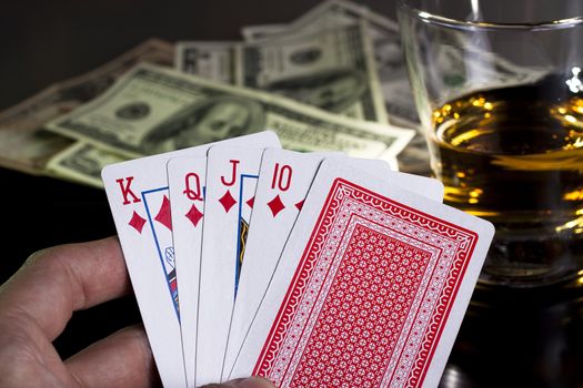 poker playing cards dollars and a whiskey glass