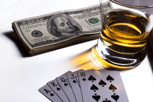 poker playing cards dollars and a whiskey glass