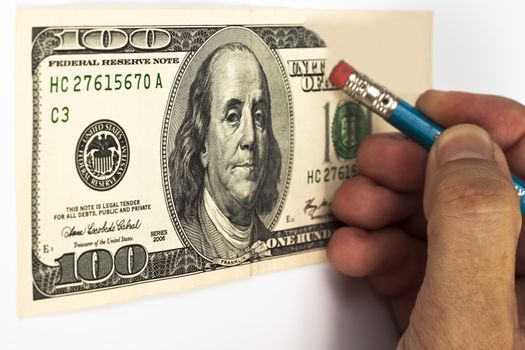 erasing a 100 dollar bill with a blue pencil whith red eraser