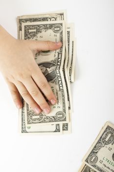 child hand holding down dollar bills on white background