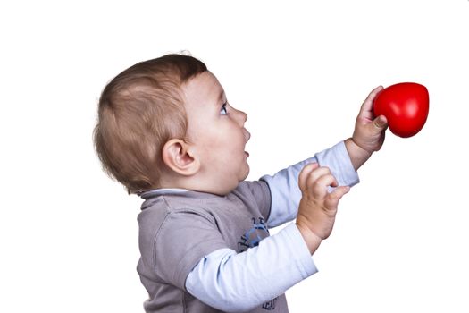 littele boy holding a red heart on white background