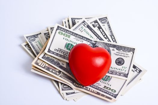 red heart and dollar bills on white background