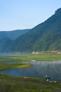 two man fishig in  a mountain lake early in the morning