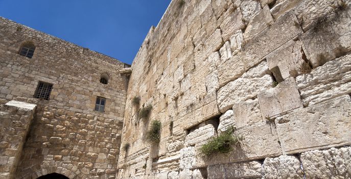 a corner of the western wall in jerusalem with some blue sky
