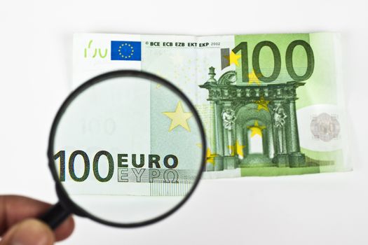 one hundred euro with magnifying glass on white background