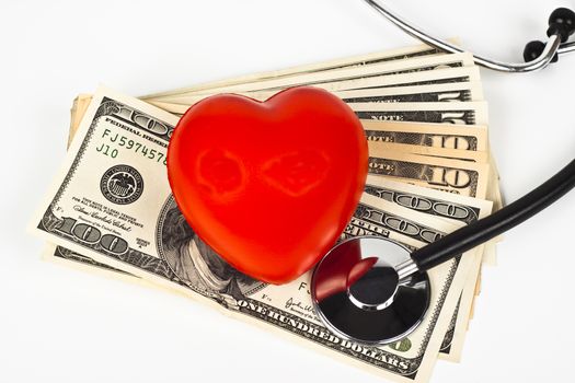 red heart dollar bills and a stethoscope on white background