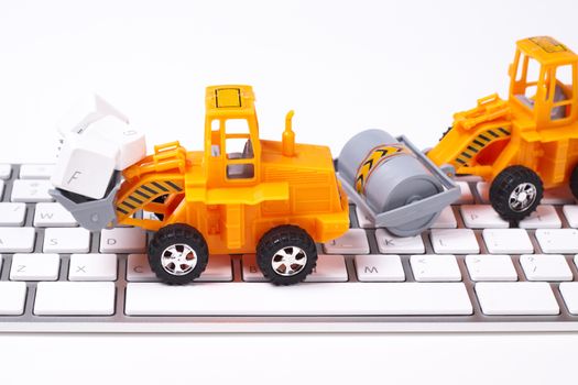 orange billdozer dissasemblyint keys on a white keyboard on white background