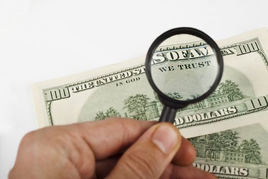 magnifying a dollar bill with a magnifying glass on white background