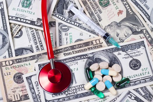 dollars  colored pills seringe and a red stethoscope