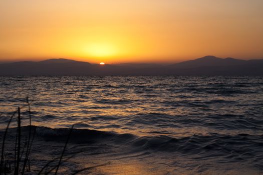 susnet over the mountain  and the sun reflecting in the sea