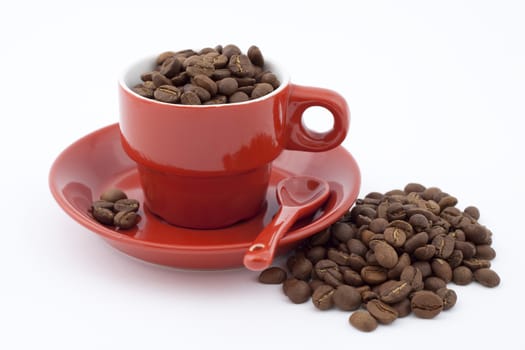 red coffee cup with plate full of coffee beans on white background