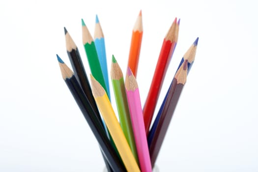colored pencils standing upwords on white background