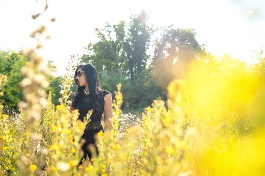 young beautiful fashion girl in yellow field wearing sunglasses