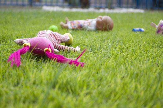 old dolls left outside in the grass 