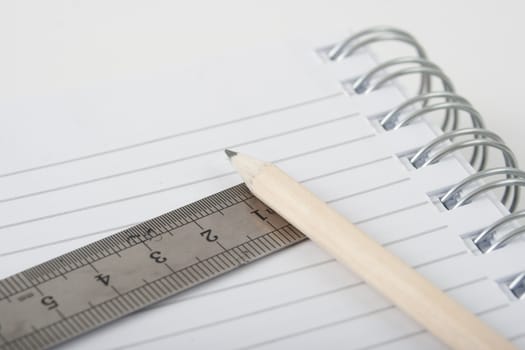 spiral note pad with a pencil and a ruler