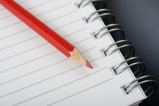 red pencil and a spiral notebook