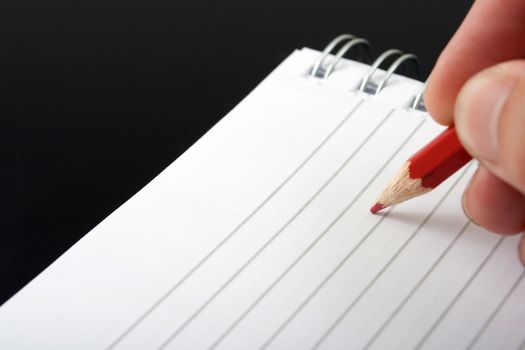 red pencil and a spiral notebook