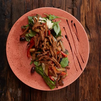 Salad baked eggplant with green onions, croutons and tomatoes on wooden background