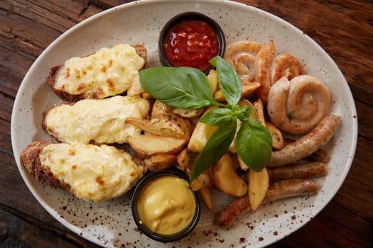 Grilled assorted sausages with French fries, bruschettes with cheese and sauces