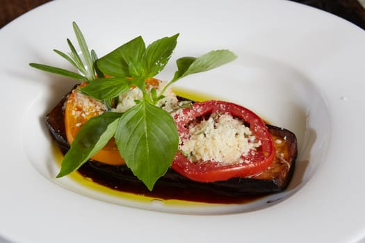 Baked eggplant with parmesan cheese, tomatoes and basil